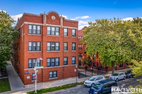 A red brick building with a tree in front of it.