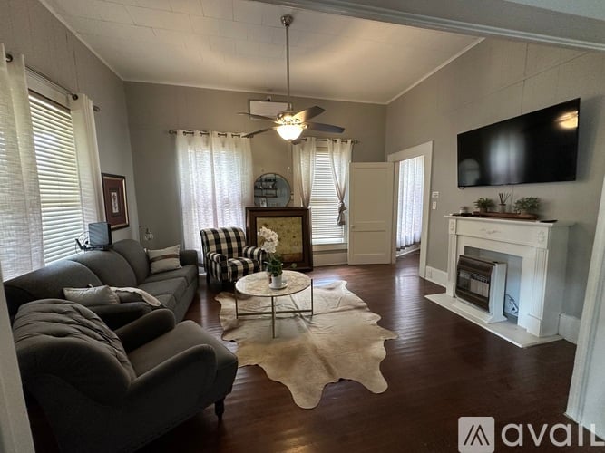A living room with a grey couch, a white coffee table, and a fireplace.