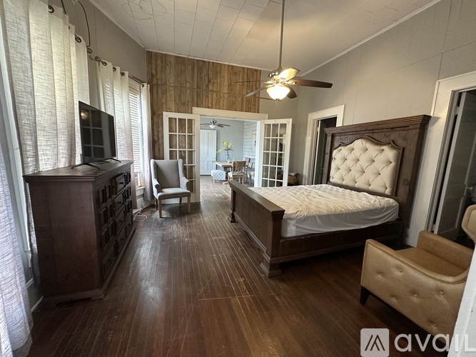 A bedroom with a bed, chair, and dresser.