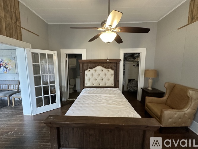 A bedroom with a large bed and a ceiling fan.