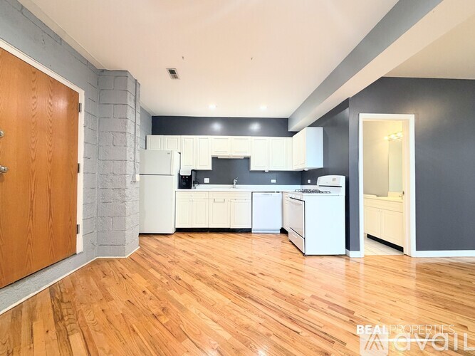 A kitchen with white appliances and wooden floors.