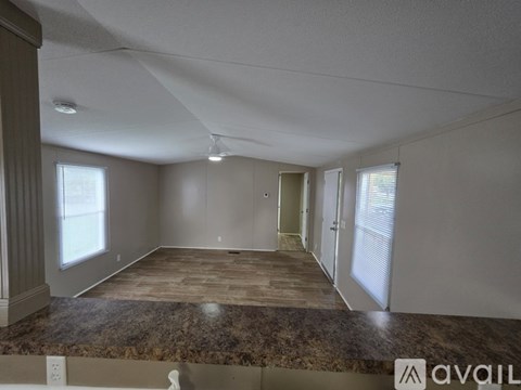 A spacious room with a marble countertop and wooden flooring is available for rent.