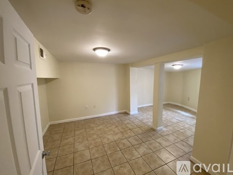 A room with beige walls and tiled flooring is available for rent.