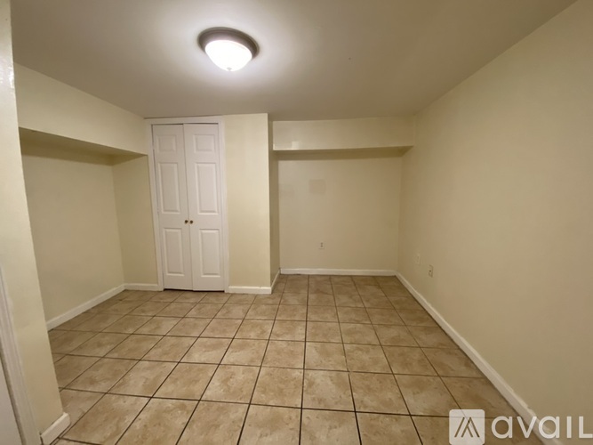 A room with a white door and tiled floor.