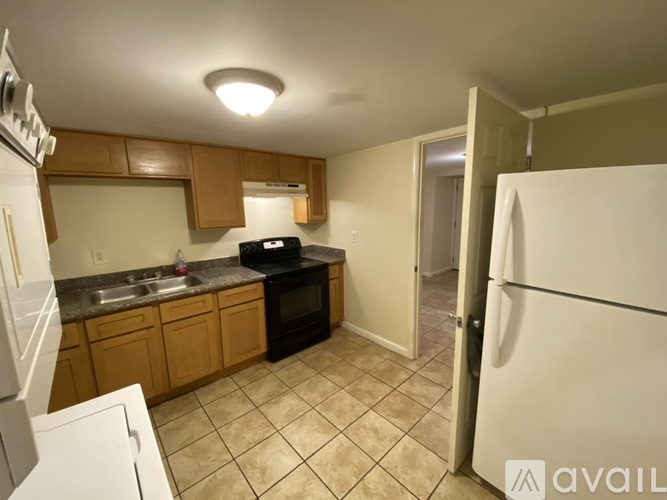 A kitchen with a black oven and white fridge.