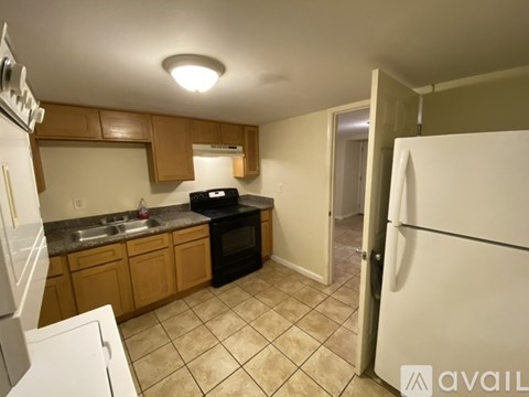 A kitchen with a black oven and white fridge.