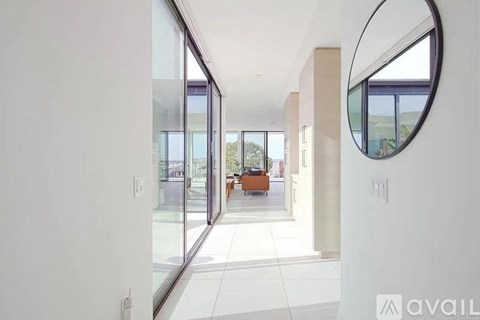 A modern interior space with a glass door leading to a balcony.