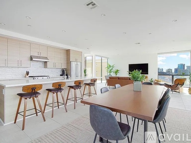 A modern kitchen with a dining table and chairs.
