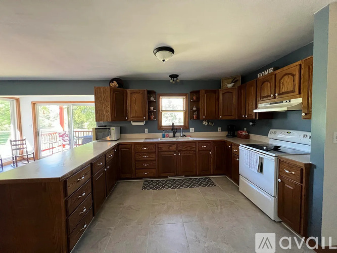 A kitchen with wooden cabinets and a white stove top oven.
