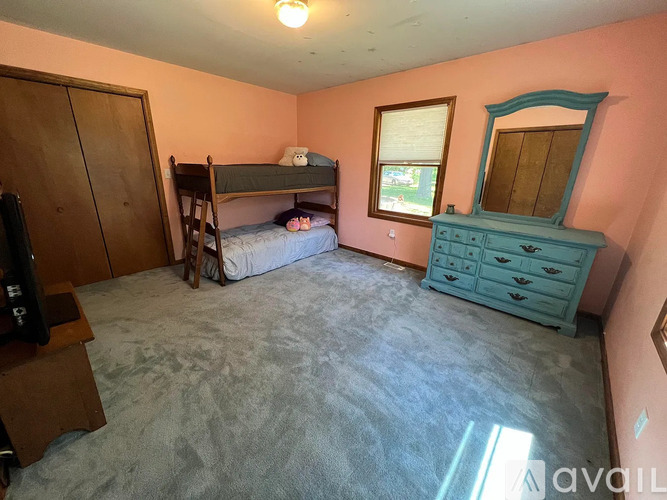 A bedroom with a bunk bed and a dresser.
