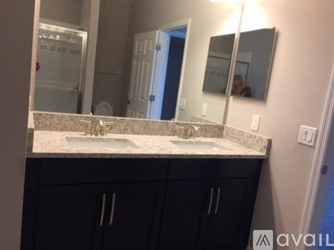 A bathroom with a sink, mirror, and cabinets.