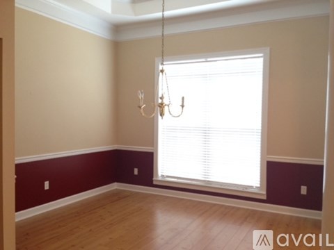 A room with a window and a chandelier.