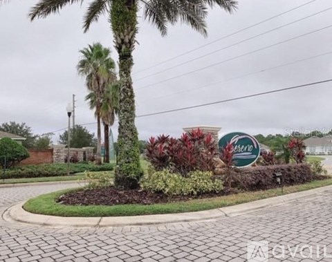 A sign for a community named "Sunrise" is surrounded by a landscaped garden.