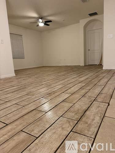 A room with wooden flooring and a ceiling fan.