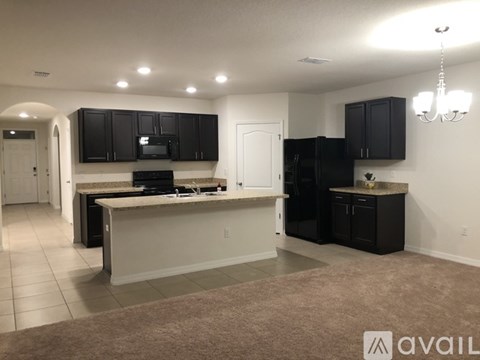 A kitchen with black cabinets and a white island.