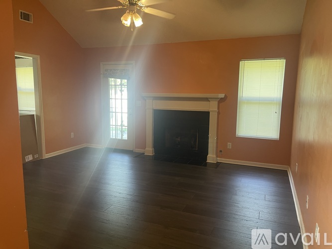 A room with a fireplace and a ceiling fan.