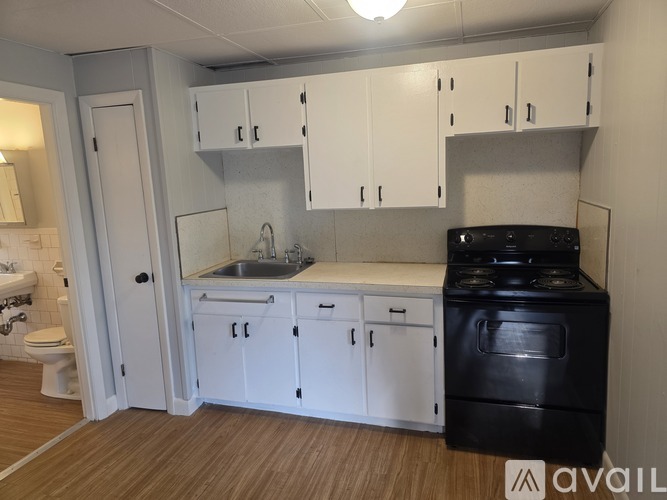 A kitchen with white cabinets and a black stove top oven.
