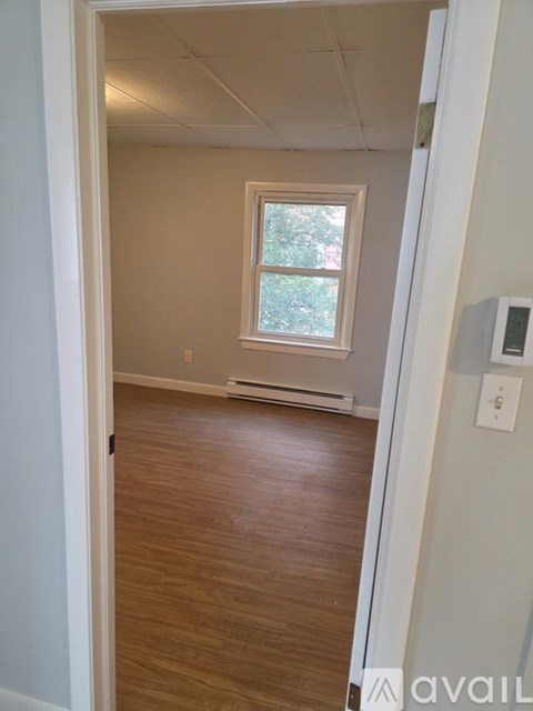 A room with a window and wooden flooring.