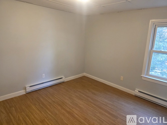 A room with a window and a wall-mounted air conditioner.