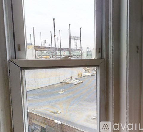 A view from a window looking out to a parking lot and a building.