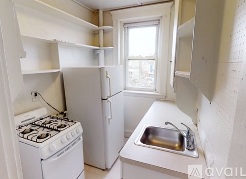 A small kitchen with a stove, sink, and refrigerator.