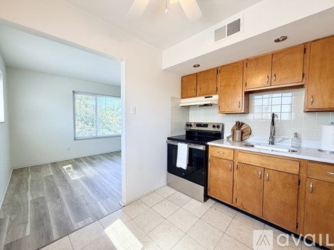 A kitchen with wooden cabinets and a stove top oven.