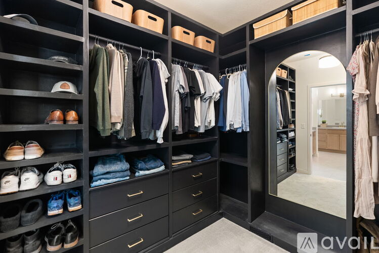 A spacious walk-in closet with neatly organized clothes and shoes.