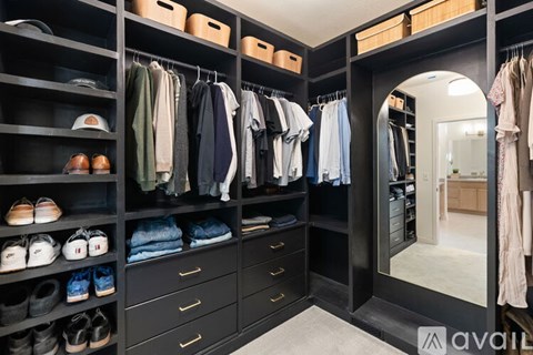 A spacious walk-in closet with neatly organized clothes and shoes.