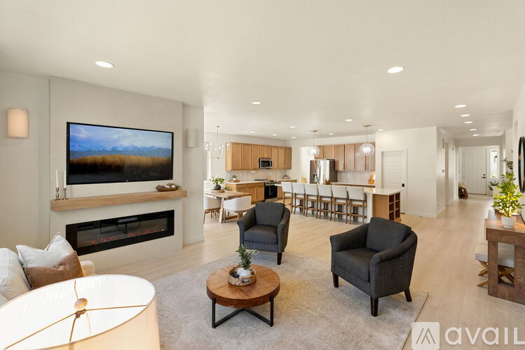 A living room with a fireplace and a television on the wall.