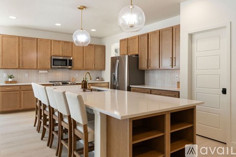 A kitchen with wooden cabinets and a white island.