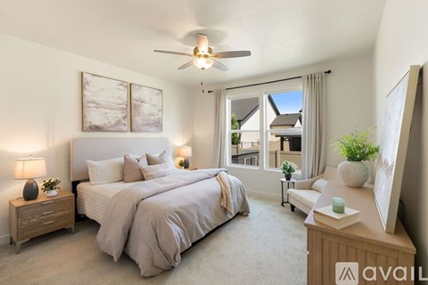 A well-lit bedroom with a large bed and a ceiling fan.