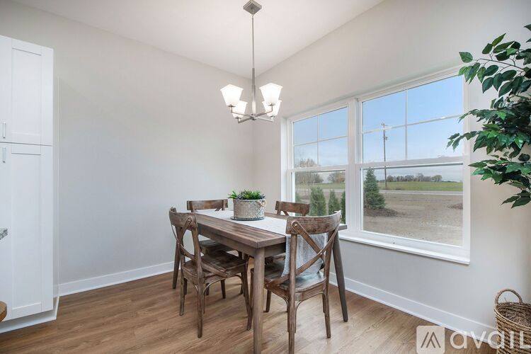 A dining room with a wooden table and chairs.