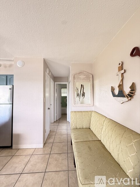 A kitchen with a fridge and a couch.