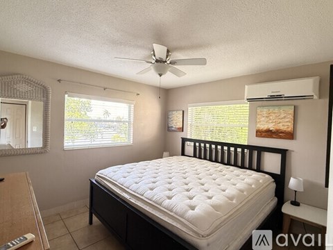 A bedroom with a large bed and a ceiling fan.