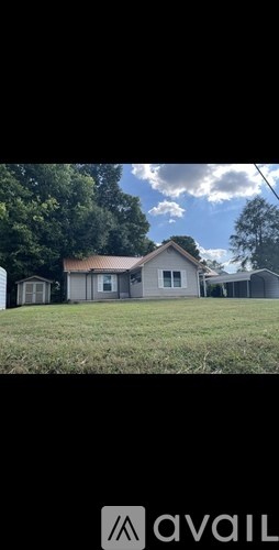 A house with a white roof and a brown fence is in the image.