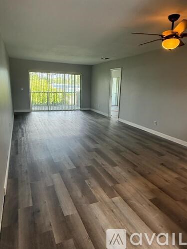 A room with wooden flooring and a ceiling fan.