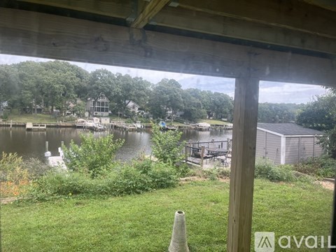 A view from a porch looking out at a lake and a dock.