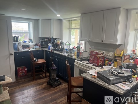 A kitchen with a black counter and white cabinets.