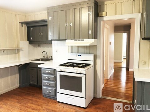 A kitchen with a white stove top oven and a black microwave above the stove.