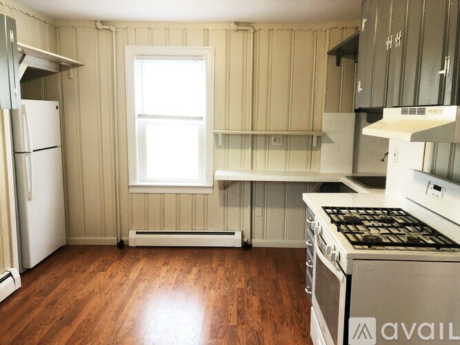A kitchen with wooden floors and white appliances.
