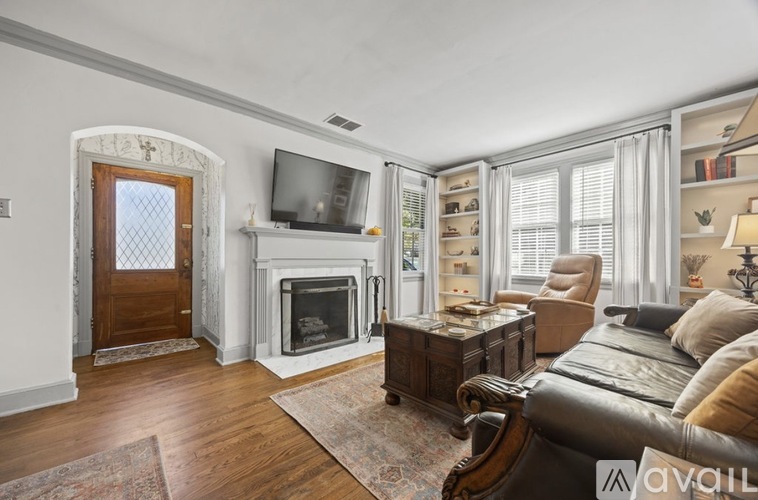 A living room with a fireplace and a television.