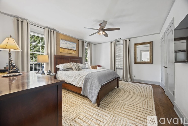 A bedroom with a bed, a ceiling fan, and a rug.