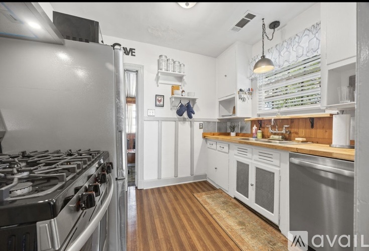 A kitchen with a stove, cabinets, and a countertop.