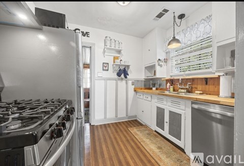 A kitchen with a stove, cabinets, and a countertop.