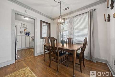 A dining room with a wooden table and chairs.