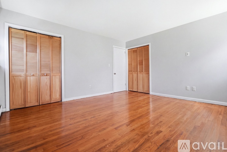 A room with wooden floors and two wooden doors.