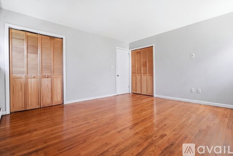 A room with wooden floors and two wooden doors.