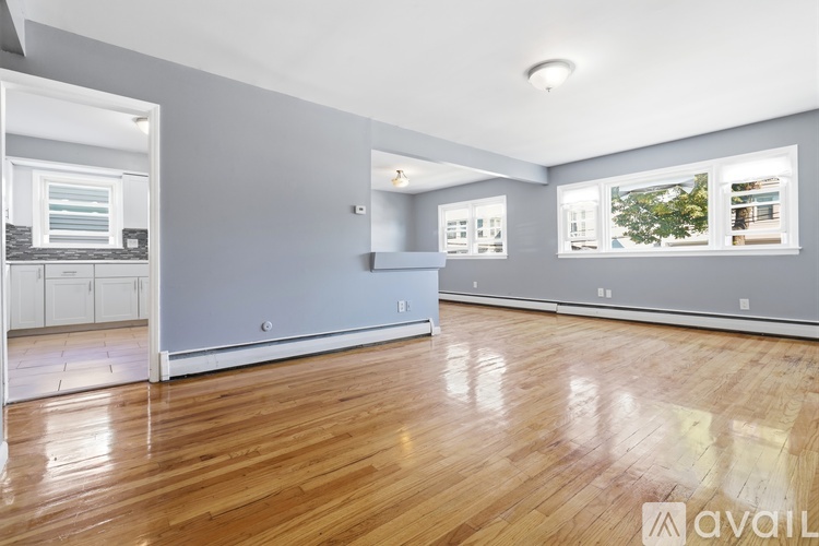 A spacious room with wooden floors and a large window.