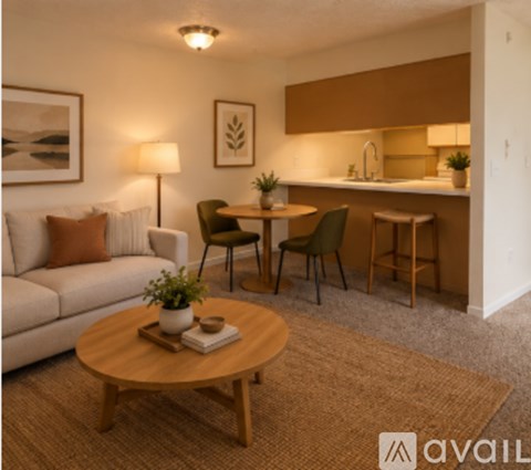 A living room with a couch, a coffee table, and a dining area with a sink.