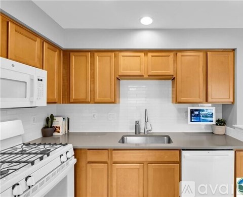 A kitchen with wooden cabinets and a white stove top oven.